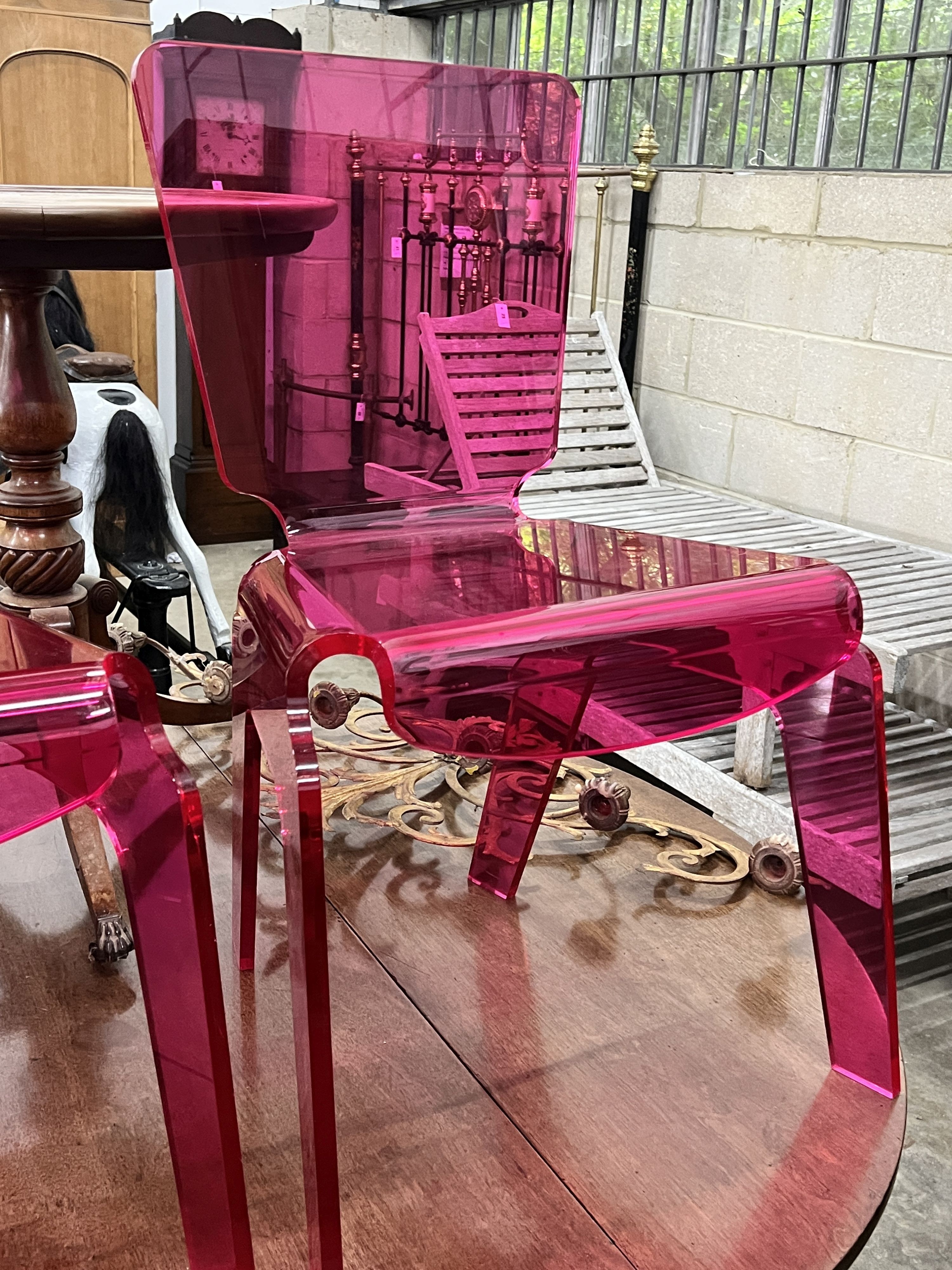 A pair of pink modern design perspex chairs, width 52m, height 84cm